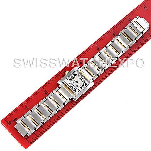 This image shows the Cartier Tank Française watch laid flat along a red ruler, displaying the watch band and face.