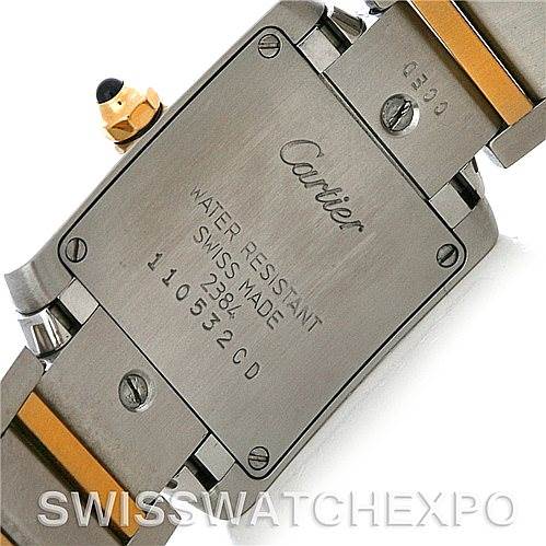 This image shows the case back and part of the bracelet of a Cartier watch, showcasing the engraved details and metal links.