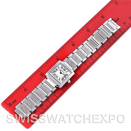 The Cartier Tank Française watch is shown from a top-down angle, displaying its rectangular face and metal bracelet fully extended next to a ruler.