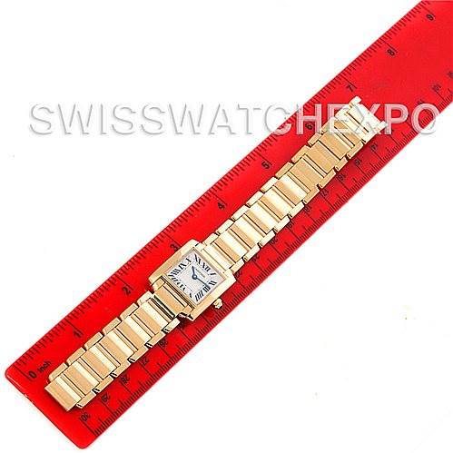 This image shows a Cartier Tank Francaise W50002N2 Women's Yellow Gold Silver Dial W50002N2 Women's Yellow Gold Silver Dial watch from a top-down angle, lying next to a red ruler.