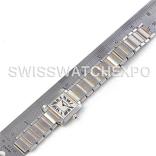 The image shows a top-down view of a Cartier Tank Française watch with its strap aligned next to a ruler.