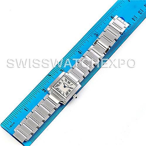 This image shows a Tank Francaise watch by Cartier laid flat next to a blue ruler, displaying its face and metal bracelet.