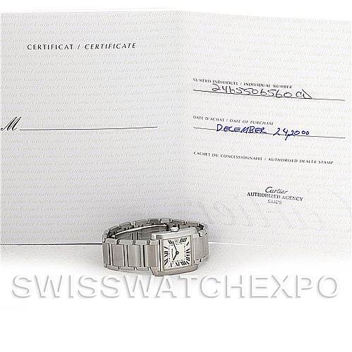 The image shows a Cartier Tank Francaise W51011Q3 Women's Stainless Steel Silver Dial W51011Q3 Women's Stainless Steel Silver Dial watch laying flat with an open certificate behind it.