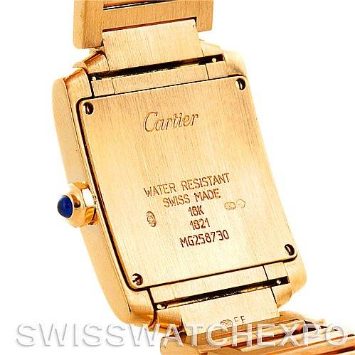 The image shows the back case and part of the strap of a Cartier Tank Francaise W50003N2 Women's Yellow Gold Silver Dial W50003N2 Women's Yellow Gold Silver Dial watch, highlighting its inscriptions and gold color.