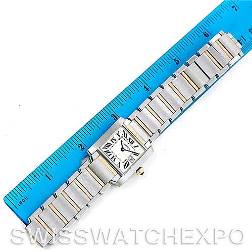 The image shows a Cartier Tank Francaise W51012Q4 Women's Steel and Gold (two tone) Silver Dial W51012Q4 Women's Steel and Gold (two tone) Silver Dial watch, placed horizontally with a blue ruler for scale, showcasing its face and metal bracelet.