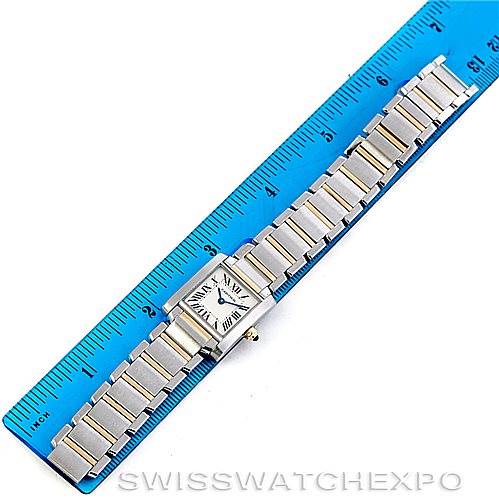 The Cartier Tank Française watch is shown from a top-down angle, positioned beside a blue ruler for scale.