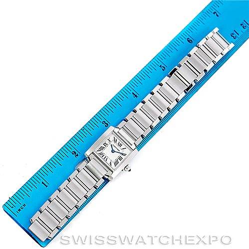 The Tank Francaise model by Cartier is shown from a top view, with the entire watch and metal bracelet laid out against a blue ruler.