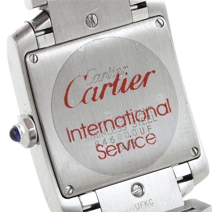 The image shows the back case and crown of a Cartier Tank Française watch with "International Service" engraved.