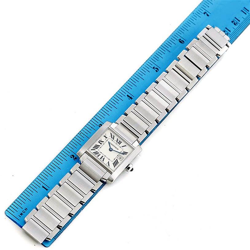 The image shows a Cartier Tank Francaise W51011Q3 Women's Stainless Steel Silver Dial W51011Q3 Women's Stainless Steel Silver Dial watch laid flat on a ruler, displaying its face and metal bracelet.
