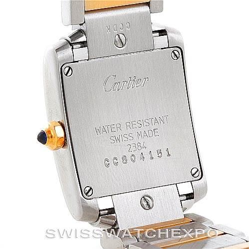 This image shows the back case of a Cartier Tank Francaise W51007Q4 Women's Steel and Gold (two tone) Silver Dial W51007Q4 Women's Steel and Gold (two tone) Silver Dial watch, including its screws, inscriptions, and bracelet attachment.