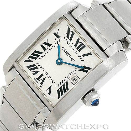The Cartier Tank Française watch is shown at an angle that displays its face, part of the bracelet, and the crown with a blue gem.