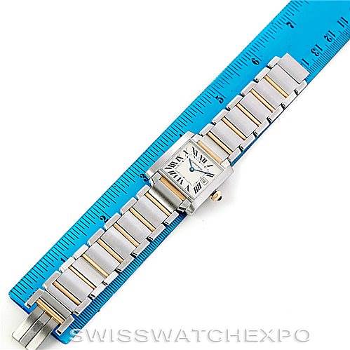 The image shows a top view of a Cartier Tank Française watch, including the face and bracelet, placed next to a ruler.