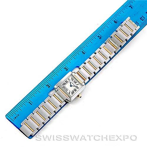 The Cartier Tank Française watch is displayed from an overhead angle next to a ruler, showcasing its bracelet and face.