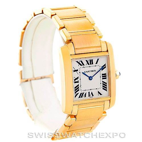 The image shows a Cartier Tank Francaise W50003N2 Women's Yellow Gold Silver Dial W50003N2 Women's Yellow Gold Silver Dial watch at an angle showcasing its square face and gold bracelet.