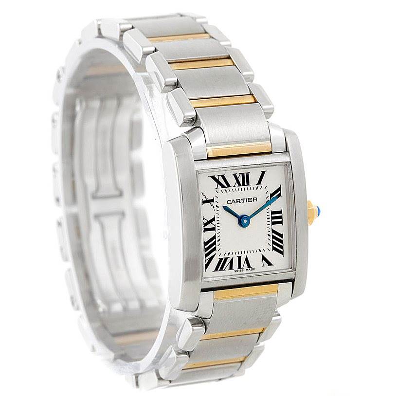 The image shows a Cartier Tank Francaise W51007Q4 Women's Steel and Gold (two tone) Silver Dial W51007Q4 Women's Steel and Gold (two tone) Silver Dial watch viewed from an angle highlighting the dial, bracelet, and crown with a blue jewel.
