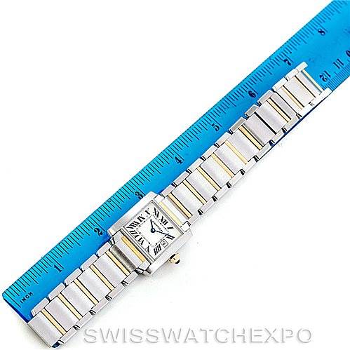 This is an overhead view of a Cartier Tank Francaise W51012Q4 Women's Steel and Gold (two tone) Silver Dial W51012Q4 Women's Steel and Gold (two tone) Silver Dial watch, showing its face and full bracelet alongside a ruler for scale.