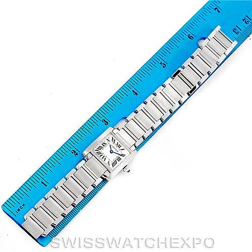 The image shows a top-down view of a Cartier Tank Française watch with a metal bracelet next to a blue ruler.