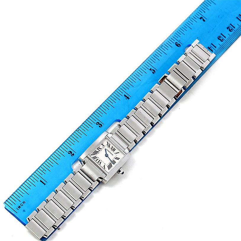 The Tank Francaise model by Cartier is shown from a top-down angle, displaying the full bracelet and face beside a ruler.