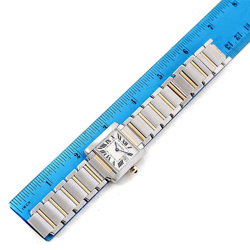 This image shows a Cartier Tank Francaise W51012Q4 Women's Steel and Gold (two tone) Silver Dial W51012Q4 Women's Steel and Gold (two tone) Silver Dial watch laid flat next to a blue ruler for measurement.