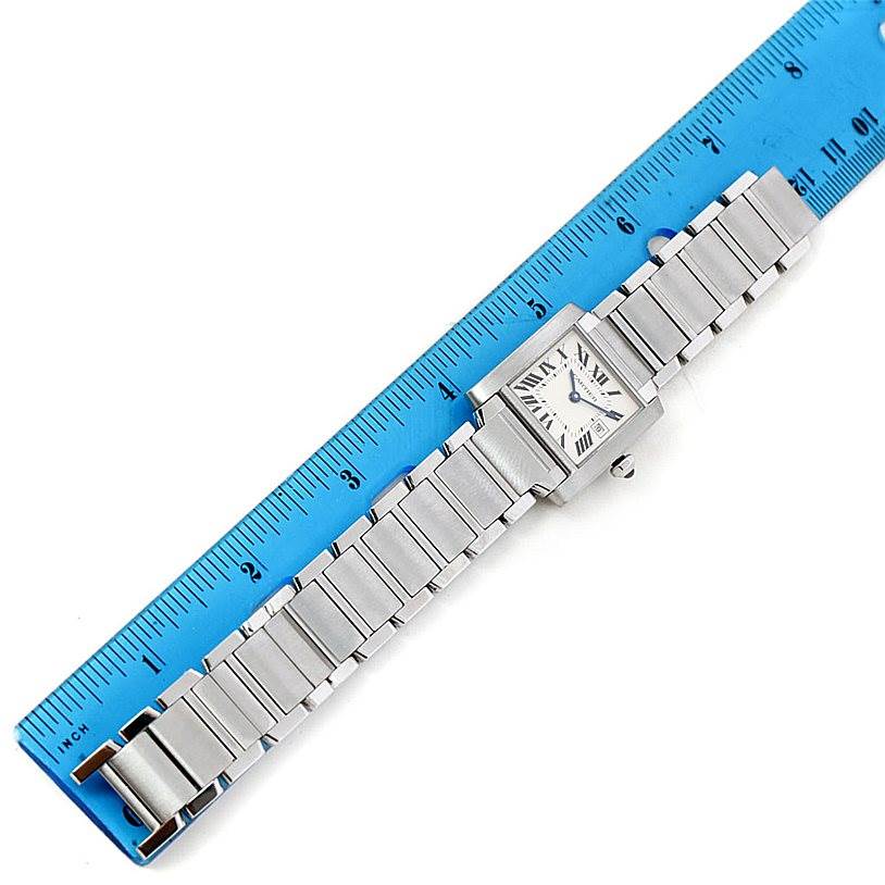 The image shows a Cartier Tank Française watch displayed alongside a blue ruler for size reference.