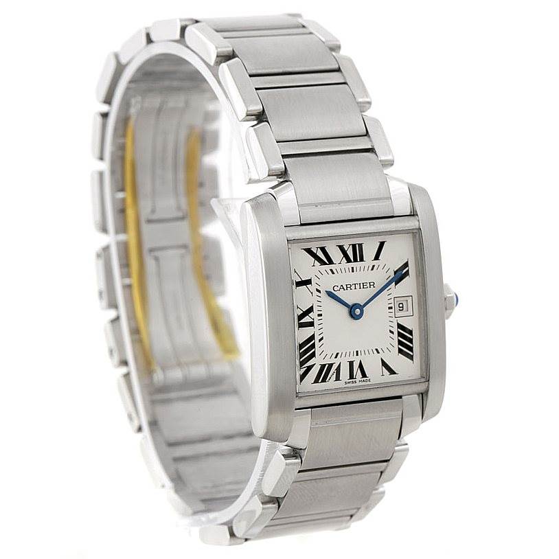The Cartier Tank Française watch is shown at an angle displaying its silver rectangular face, Roman numeral dial, and metal bracelet.