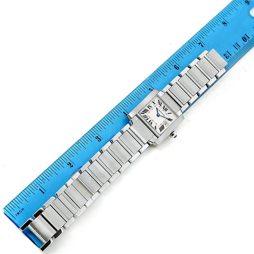 The image shows a Cartier Tank Française watch placed beside a blue ruler, displaying its full length and bracelet.