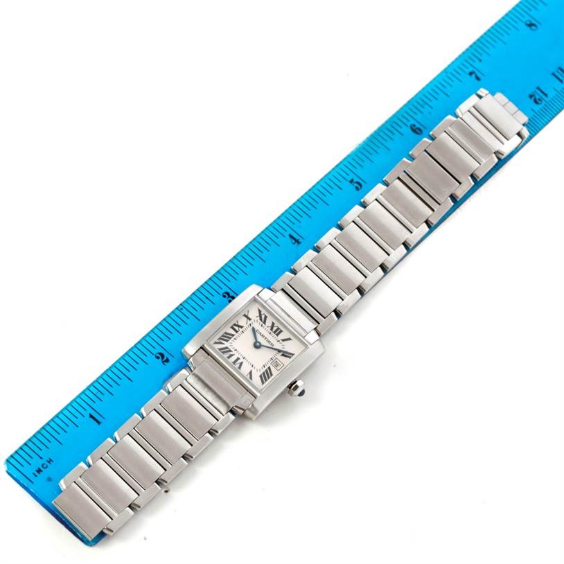 The Cartier Tank Francaise W51011Q3 Women's Stainless Steel Silver Dial W51011Q3 Women's Stainless Steel Silver Dial watch is shown in a top-down view alongside a blue ruler, displaying its entire bracelet and face.