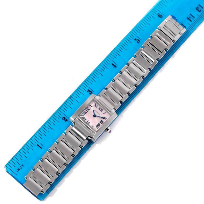 The image shows an overhead view of a Cartier Tank Francaise W51031Q3 Women's Stainless Steel Silver Dial W51031Q3 Women's Stainless Steel Silver Dial watch, laying on a ruler, displaying the watch face and metal bracelet.