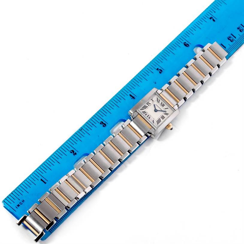 The Cartier Tank Francaise W51007Q4 Women's Steel and Gold (two tone) Silver Dial W51007Q4 Women's Steel and Gold (two tone) Silver Dial watch is shown from an overhead angle, aligned next to a blue ruler, highlighting the entire wristband and watch face.