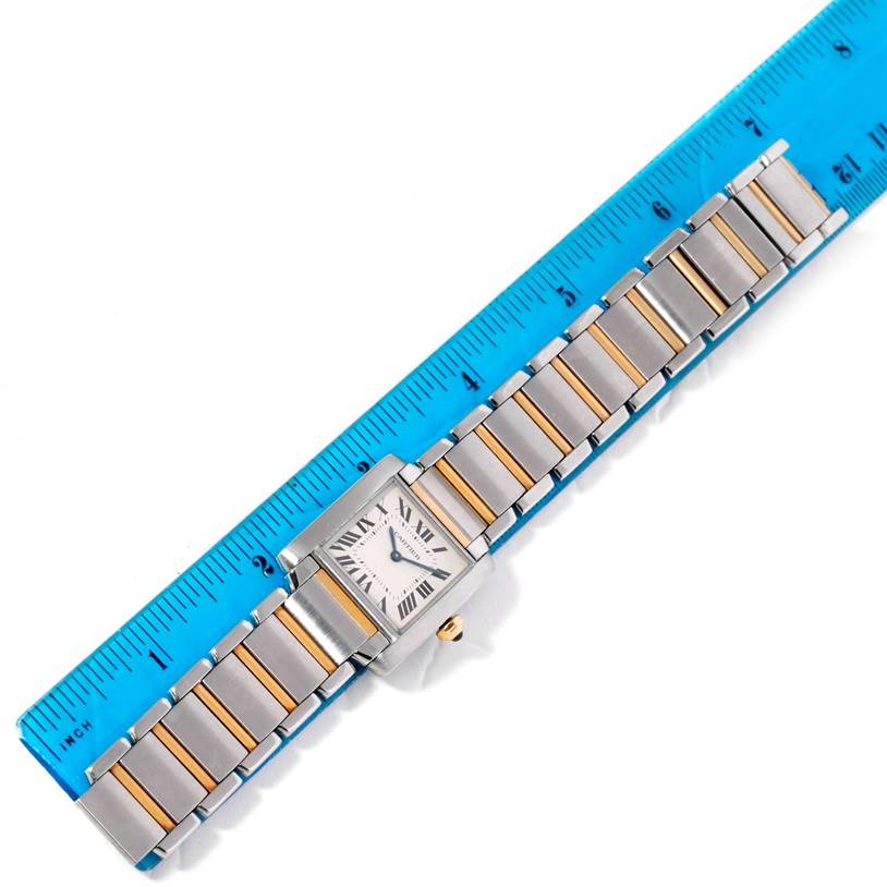 The Tank Francaise model by Cartier is shown from an overhead angle with the full bracelet displayed next to a blue ruler.
