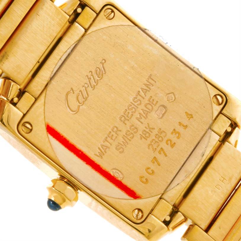 This image shows the back case of a Cartier Tank Francaise W50002N2 Women's Yellow Gold Silver Dial W50002N2 Women's Yellow Gold Silver Dial watch, highlighting the engraved details and gold metal strap.