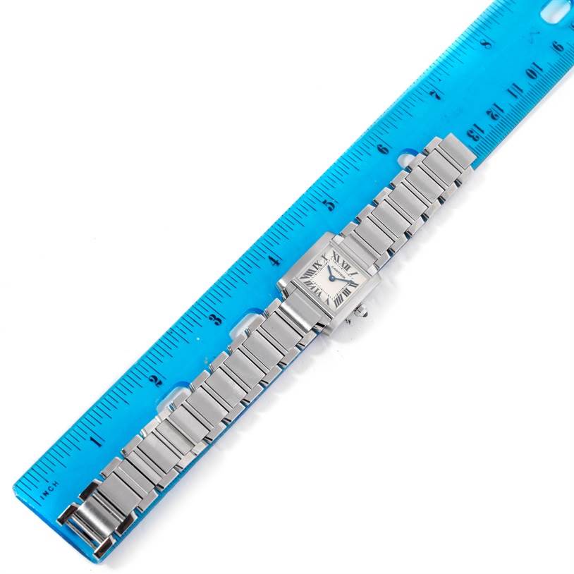 The Cartier Tank Francaise W51008Q3 Women's Stainless Steel Silver Dial W51008Q3 Women's Stainless Steel Silver Dial watch is shown from a top-down angle, displaying its face, bracelet, and part of the crown alongside a ruler.