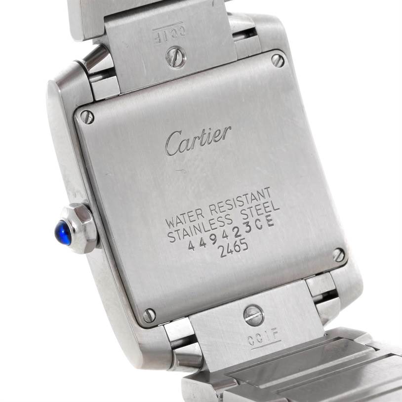 The image shows the back case and part of the bracelet of a Cartier Tank Française watch, highlighting its inscription and stainless steel material.
