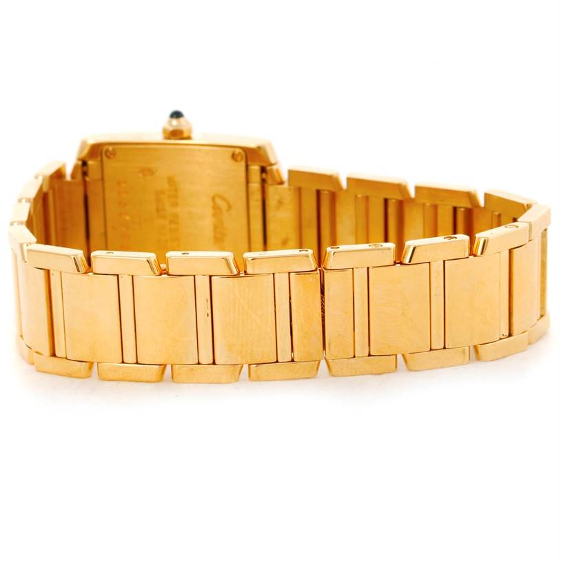 The image shows the back of a Cartier Tank Française watch, highlighting its gold bracelet and the back of its rectangular case.