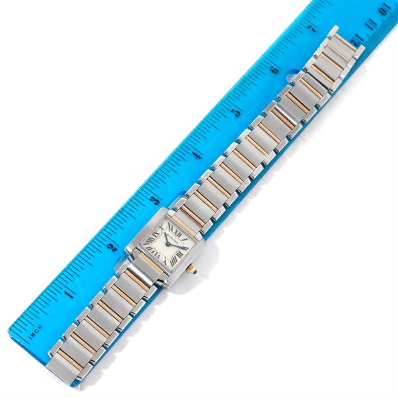 The Cartier Tank Francaise W51007Q4 Women's Steel and Gold (two tone) Silver Dial W51007Q4 Women's Steel and Gold (two tone) Silver Dial watch is shown from a top-down angle alongside a blue ruler, highlighting its face and bracelet.