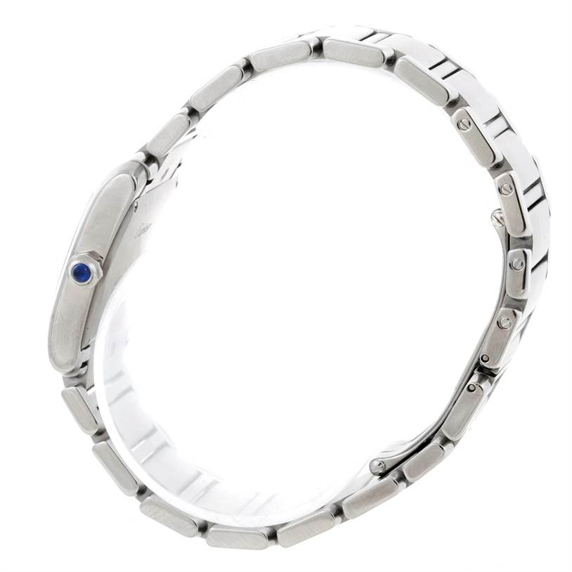 The image shows a side view of a Cartier Tank Française watch, highlighting its metal bracelet and crown with a blue stone.