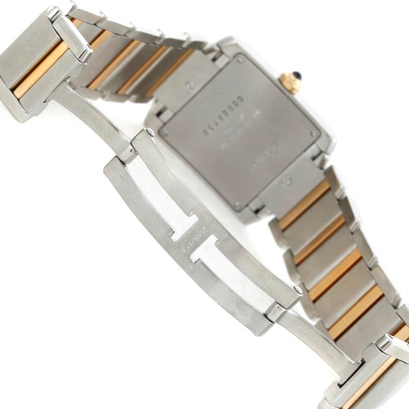 The image shows the back of a Cartier Tank Francaise W51012Q4 Women's Steel and Gold (two tone) Silver Dial W51012Q4 Women's Steel and Gold (two tone) Silver Dial watch and part of its metallic bracelet clasp.