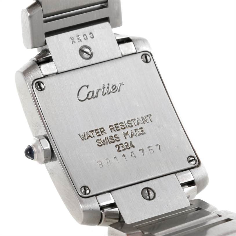 The image shows the back case of a Cartier Tank Française watch, highlighting the engravings and part of the bracelet.
