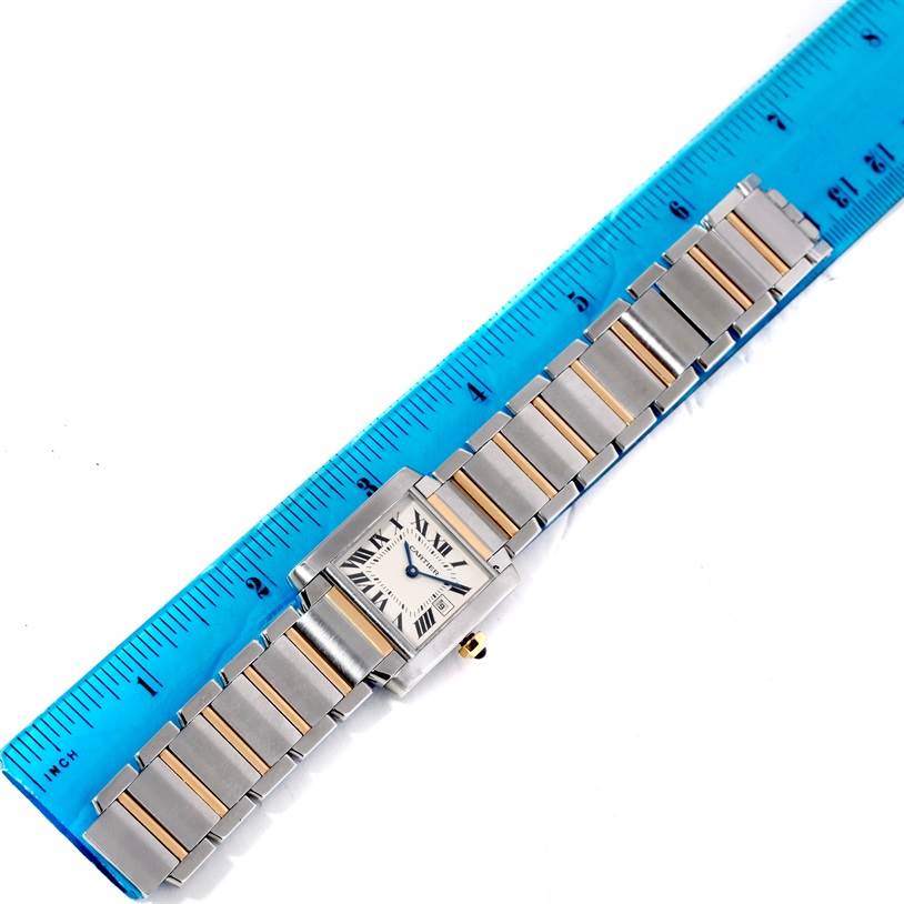 The image shows the full length of a Cartier Tank Francaise W51012Q4 Women's Steel and Gold (two tone) Silver Dial W51012Q4 Women's Steel and Gold (two tone) Silver Dial watch placed adjacent to a blue ruler for scale.