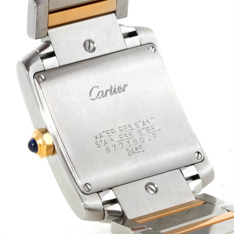 The image shows the back casing, crown, and part of the bracelet of a Cartier Tank Française watch.