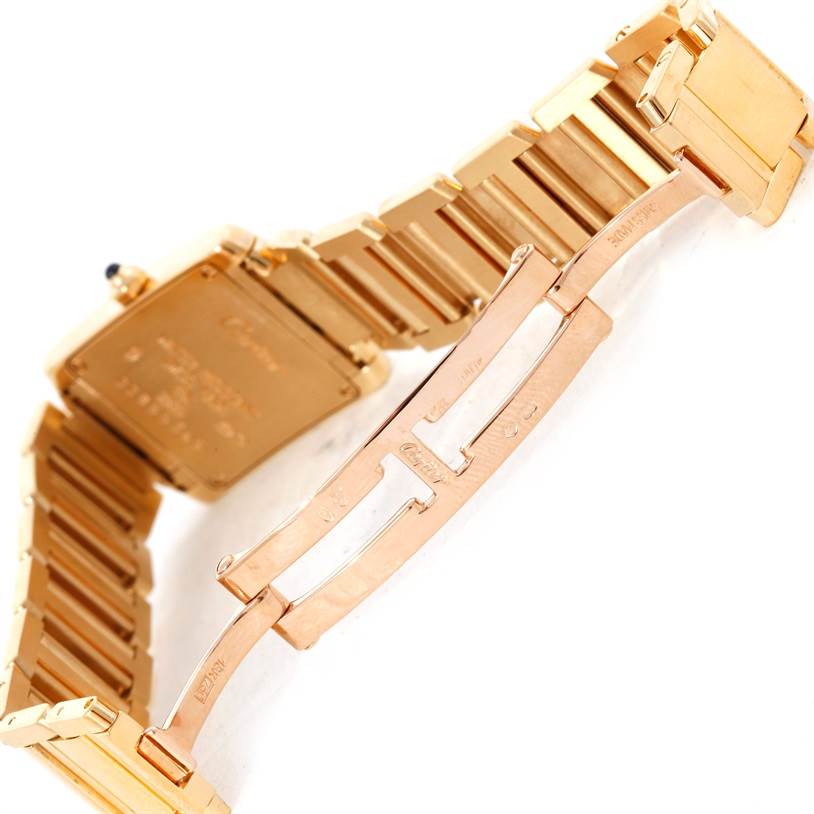 The image shows the back view and clasp of a Cartier Tank Française watch, highlighting its gold bracelet and deployment clasp.