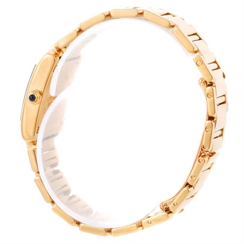 The image shows a side view of the Cartier Tank Française watch, highlighting its gold bracelet and case with a blue cabochon crown.