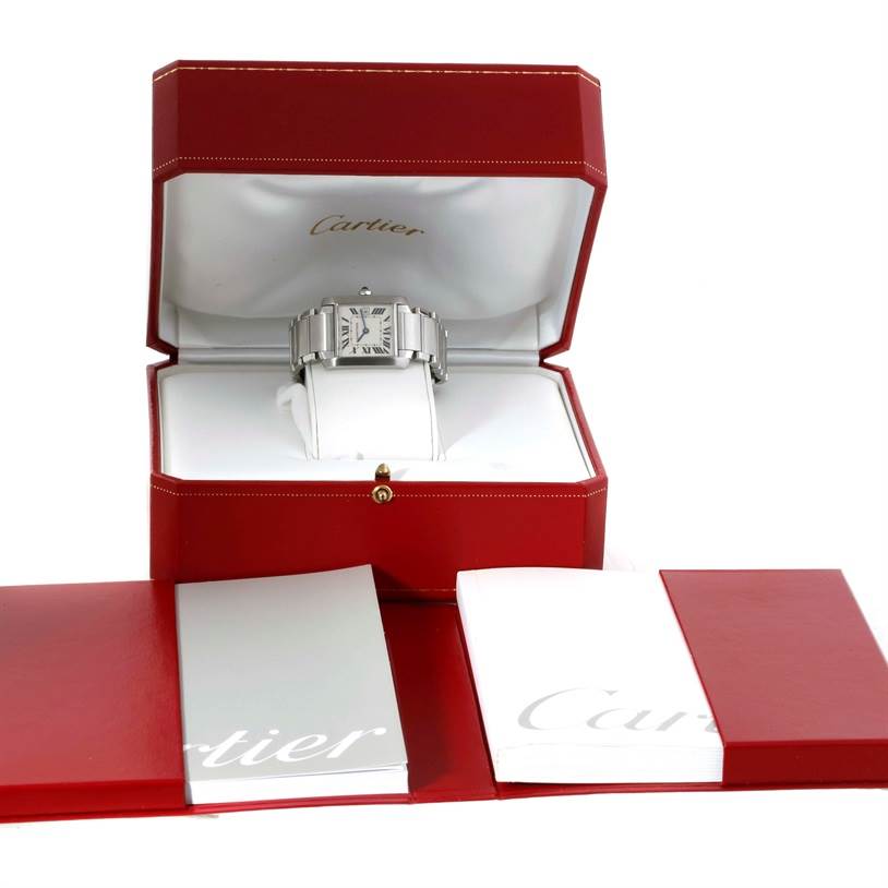 The Cartier Tank Française watch is displayed head-on in its open red box, with accompanying booklets placed in front.
