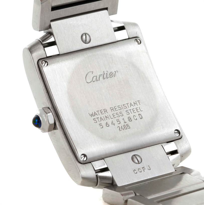 The image shows the back casing and a portion of the bracelet of the Cartier Tank Française watch, highlighting its engravings and stainless steel construction.