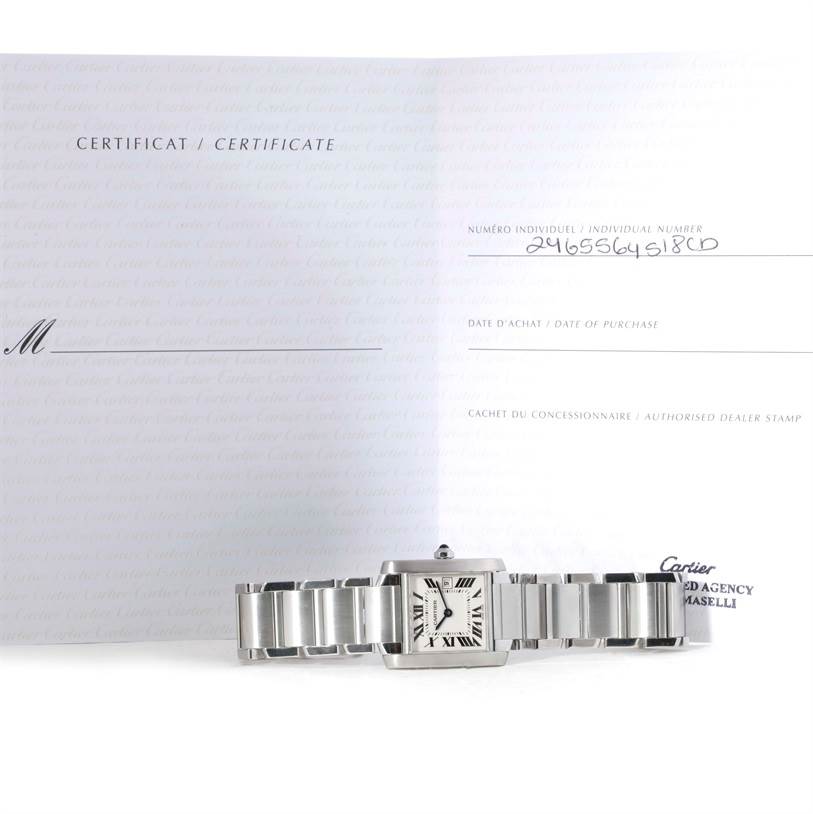 The image shows a Cartier Tank Francaise W51011Q3 Women's Stainless Steel Silver Dial W51011Q3 Women's Stainless Steel Silver Dial watch laid flat with its warranty certificate positioned behind it.