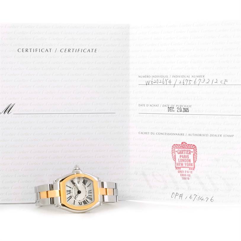 The image shows a Cartier Roadster W62026Y4 Women's Steel and Gold (two tone) Silver Dial W62026Y4 Women's Steel and Gold (two tone) Silver Dial watch laid flat alongside its certificate documentation.