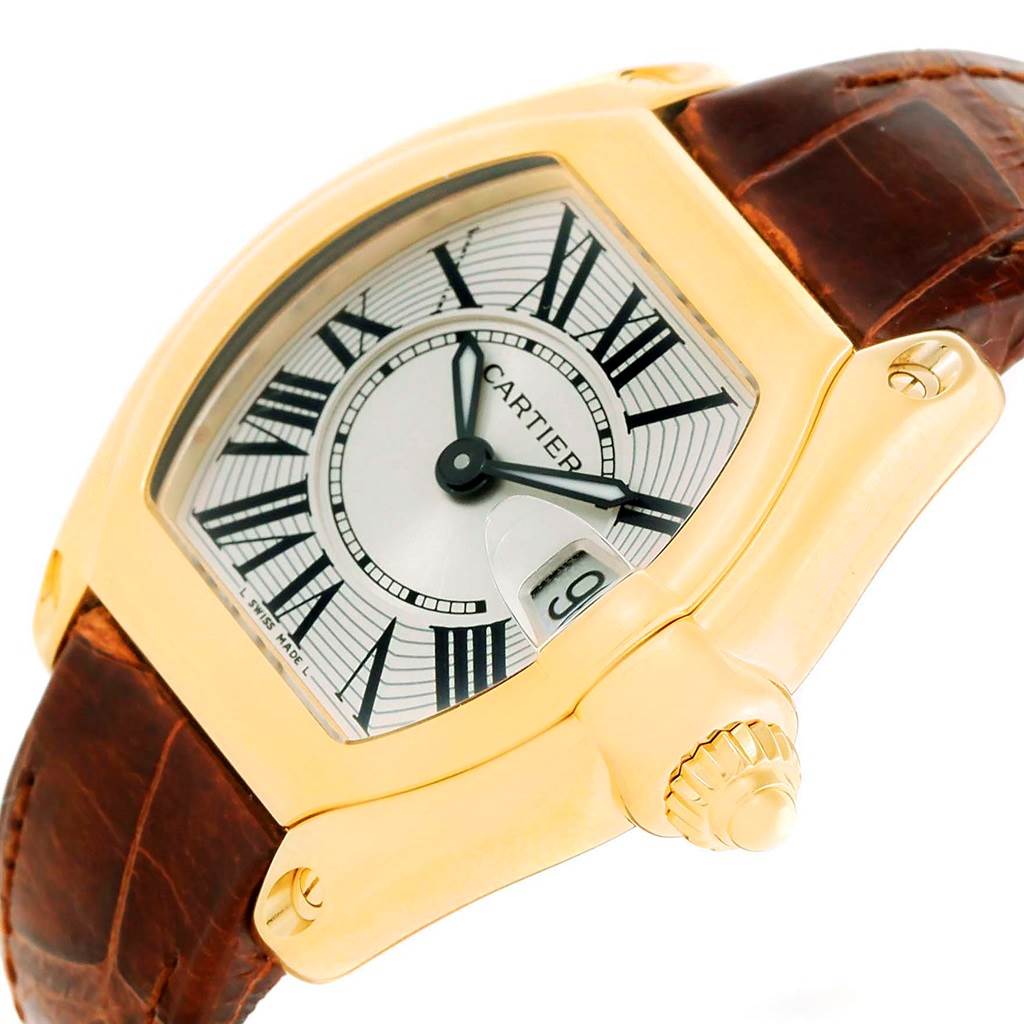 The Cartier Roadster W62018Y5 Women's Yellow Gold Silver Dial W62018Y5 Women's Yellow Gold Silver Dial watch is shown at an oblique angle, displaying the dial, case, crown, and part of the leather strap.
