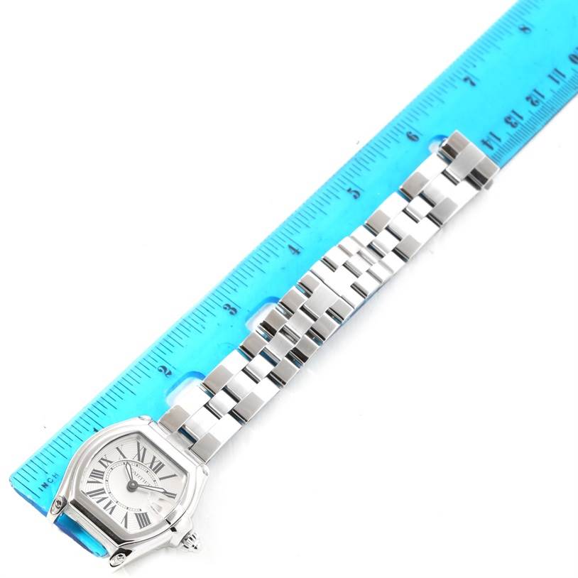 The image shows a Cartier Roadster W62016V3 Women's Stainless Steel Silver Dial W62016V3 Women's Stainless Steel Silver Dial watch from a top-down angle, featuring the face and metal bracelet, with a blue ruler for scale.