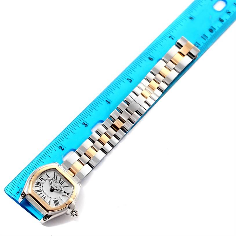 The Cartier Roadster W62026Y4 Men's Steel and Gold (two tone) Silver Dial W62026Y4 Men's Steel and Gold (two tone) Silver Dial watch is displayed flat, showing the entire band and face next to a blue ruler for scale.