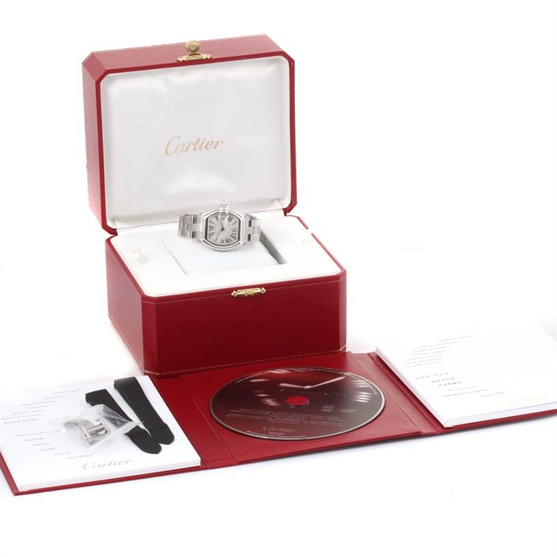 The Cartier Roadster W62016V3 Women
s Stainless Steel Silver Dial W62016V3 Women
s Stainless Steel Silver Dial watch is displayed in its open box with accompanying accessories, including straps and a CD.